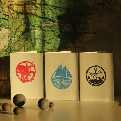 Drei handbedruckte Karten mit Linolschnitten und maritimen Motiven: Oktopus, Anker, Segelschiff