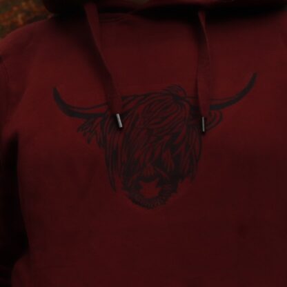 Detailaufnahme Linoldruck Kopf eines Highland Rindes, schwarzer Druck auf burgundrotem Textil