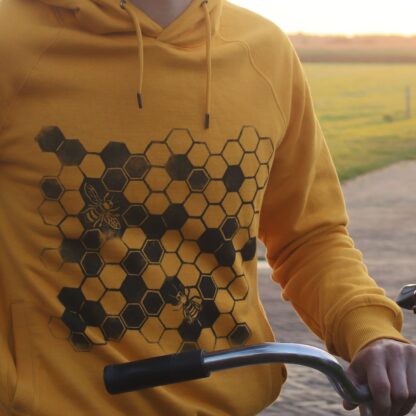 Linoldruck mit Bienenwaben als Motiv auf gelbem Hoodie, Detailaufnahme